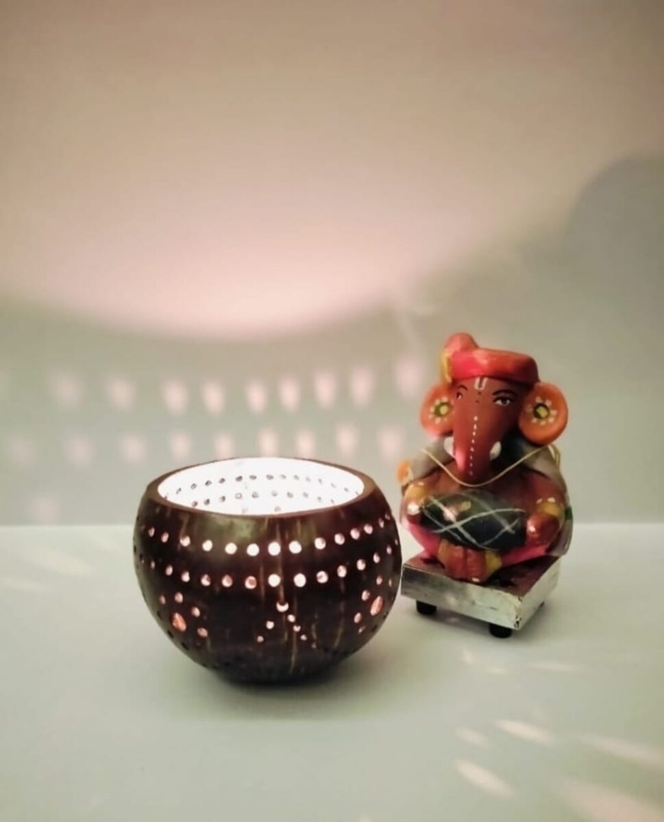 Decorative carved coconut shell tealight piece with a figurine